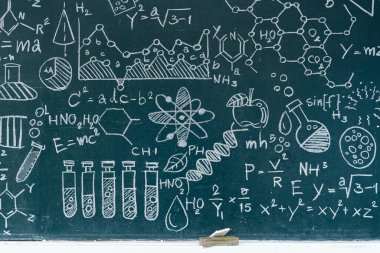 Elle çizilmiş bilimsel sembollerle, kimyasal yapılarla, fizik denklemleriyle, DNA sarmallarıyla ve atom modelleriyle kaplı bir karatahta. Eğitim, araştırma, kimya ve STEM ile ilgili içerik için ideal.