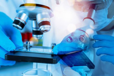 Laboratuvarda mavi ışıkta cam kaydırağını mikroskop altında ayarlayan eldivenlerle bilim adamlarının ellerini kapat. Bilimsel araştırma, tıbbi test, genetik ve biyoteknoloji yeniliği kavramı.