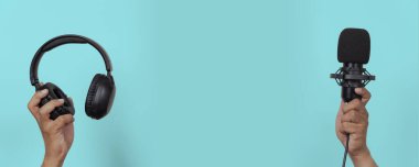 Siyah kulaklıkların ve mikrofonun mavi arka planda kapatılması, podcast, müzik kaydı, yayıncılık, stüdyo dijital medya iletişimi ve çevrimiçi yayın içeriği oluşturma kavramı için uygundur.