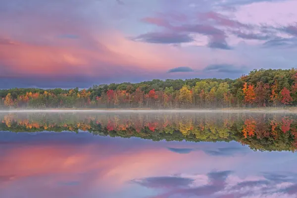 Derin Göl kıyılarının şafağında sisli sonbahar manzarası sakin sularda yansıyan yansımalarla, Yankee Springs State Park, Michigan, Usa