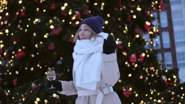 Radostná Žena Tančí Sklenicí Šampaňského Blízkosti Krásné Osvětlené Vánoční Stromeček — Stock video