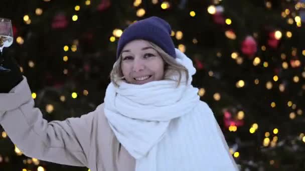 Radostná Žena Tančí Sklenicí Šampaňského Blízkosti Krásné Osvětlené Vánoční Stromeček — Stock video