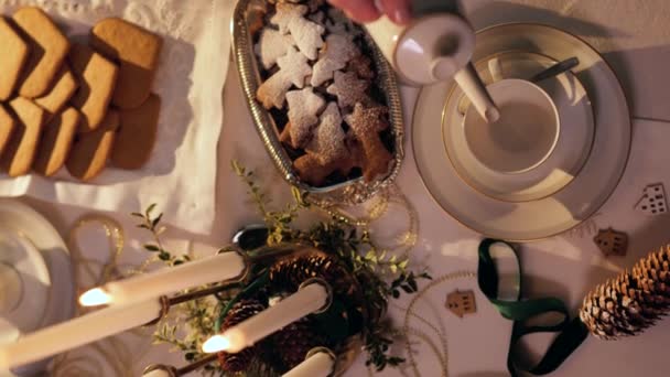 急須からお茶を注ぐ女性 クリスマステーブルのセッティング 熱いお茶を注ぐのクローズアップビューでは 蒸気カップから出てくる クリスマス 垂直または水平のビデオ — ストック動画