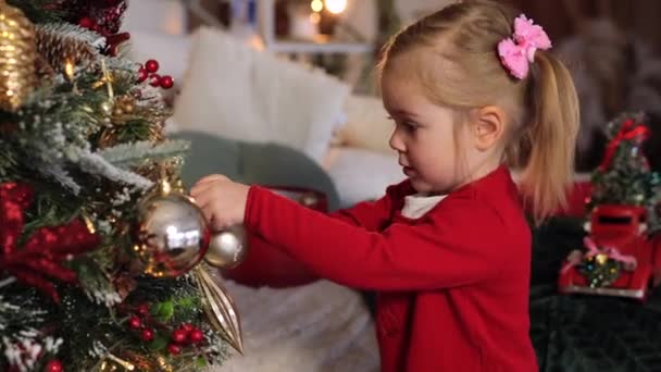 Urocza Dwuletnia Dziewczynka Czerwonym Swetrze Ozdobiona Kulkami Choinki Przytulny Dom — Wideo stockowe