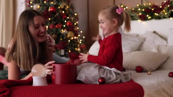 Wesoła Rodzina Leży Łóżku Bawiąc Się Pudełkami Świątecznymi Przytulnym Pokoju — Wideo stockowe