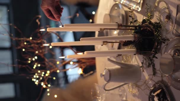 マッチを使用して女性の手光パラフィンキャンドル カップ ティーポット グラス プレート上のクッキーと美しいクリスマステーブルの設定 クリスマステーブルのセッティング クリスマスの前夜の準備 垂直ビデオ — ストック動画