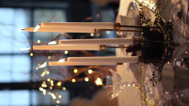 夕方には白と黄金の色でクリスマステーブルの設定 グラスキャンドル 紅茶用カップ 自然植物の枝のクローズアップビュー クリスマス 垂直ビデオ — ストック動画
