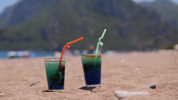 Kobiety Biorą Dwie Świeże Niebieskie Koktajle Alkoholowe Tropikalnej Piaszczystej Plaży — Wideo stockowe