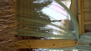 Beautiful view on empty sofa and waving in the wind curtains in a summer alcove outdoors. Summer vacations. Vertical video