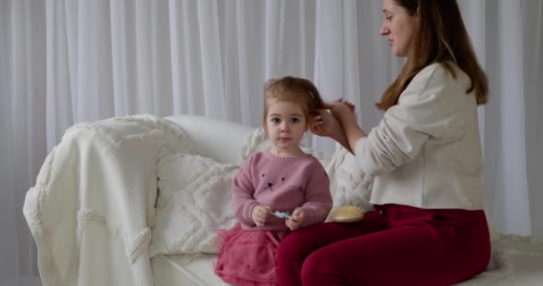 Madre Cariñosa Sentarse Sofá Blanco Casa Peina Pelo Adorable Hija — Vídeo de stock