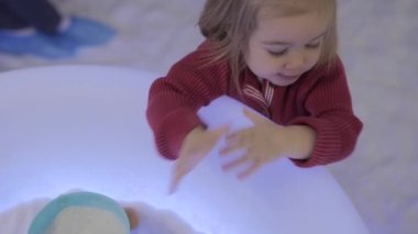 Infant girl playing in salt room. Halotherapy for kids. 