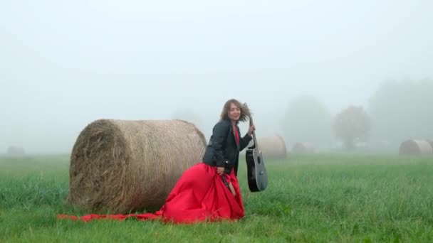 Νεαρή Γυναίκα Μακρύ Κόκκινο Φόρεμα Και Δερμάτινο Μπουφάν Χορεύει Κιθάρα — Αρχείο Βίντεο