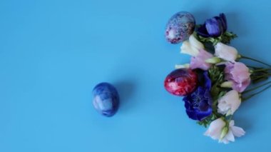 Mavi arka planda yumurta ve bir buket bahar çiçeği ve yumurta. Mutlu Paskalyalar