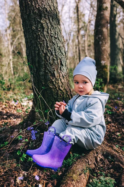 Dziewczynka Fioletowych Butach Niebieski Ogólnie Siedzi Pod Drzewem Wiosennym Lesie — Zdjęcie stockowe
