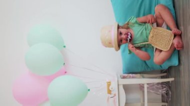 İki yıllık bebek doğum günü kutlaması, yerde oturmuş dondurma yiyen bir kız. Evde doğum günü kutlaması, minimalizm tarzı..