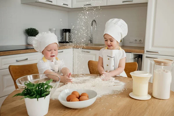Urocza Dziewczyna Kapeluszach Fartuchach Bawiąca Się Mąką Kuchni Dzieci Przygotowujące — Zdjęcie stockowe