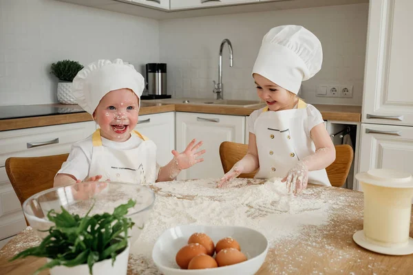 Urocza Dziewczyna Kapeluszach Fartuchach Bawiąca Się Mąką Kuchni Dzieci Przygotowujące — Zdjęcie stockowe