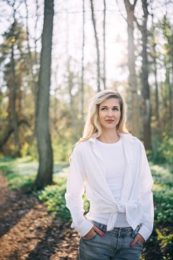 Bahar ormanlarında yürüyen genç bir kadının portresi. Doğanın tadını çıkarıyorum. Eğlence konsepti