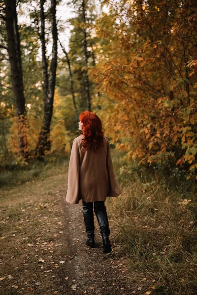 Kırmızı Boyalı Saçlı Bej Ceketli Deri Dizli Çizmeli Sonbahar Ormanlarında — Stok fotoğraf