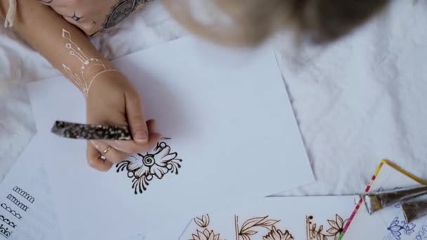 Молода Жінка Лежить Білому Аркуші Практикує Дизайн Хни Або Мейнді — стокове відео