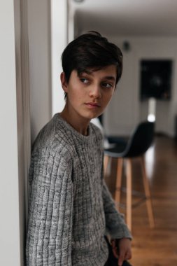 Duvarın yanında duran yakışıklı bir gencin portresi. Kenara bak.