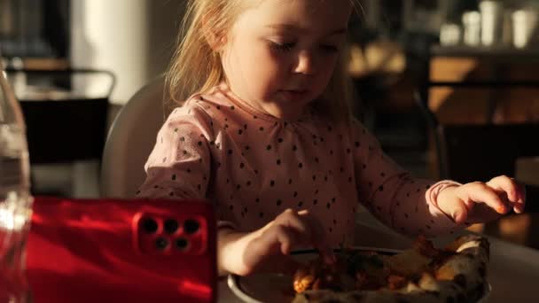 Маленькая Девочка Ест Пиццу Смотрит Мультики Смартфоне Ресторане — стоковое видео