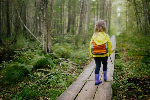 Mutlu Anaokulu Kızı Güz Ormanı Başlarında Sırt Çantasıyla Bataklıkta Yürüyor — Stok fotoğraf