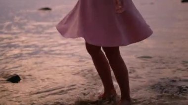 Kumsalda dans eden kadın bacakları. Suyun içinde yalın ayak dönen tanınmayan kadın kaygısız hisseder., 