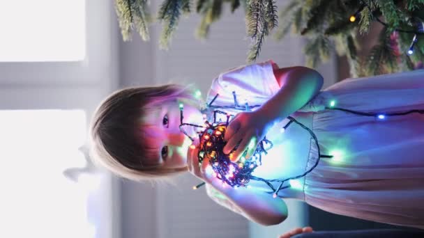 Zabawna Dziewczynka Trzymająca Rękach Cewkę Elektrycznych Girland Świątecznych Uroczysta Atmosfera — Wideo stockowe