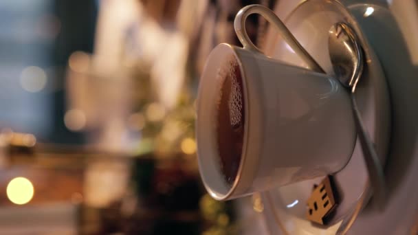 冬の夕方に泡が入った新鮮な紅茶のカップのクローズアップビュー バーティカルビデオ — ストック動画