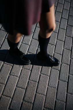 Kadın bacakları bozuk para ve siyah çoraplar giyerek sokakta yürüyor. 