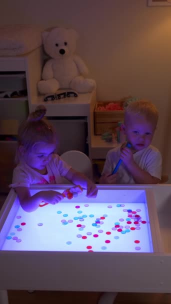 可爱的学龄前男孩和女孩玩感官盒 用磁棒收集彩色晶片 — 图库视频影像
