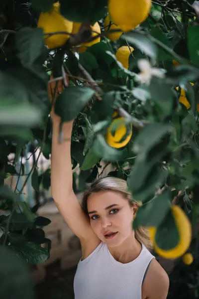 レモンの木の下に立っている健康な皮を持つ美しい若い女性の屋外の肖像画 ロイヤリティフリーのストック写真