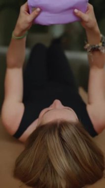 Yoga minderinde uzanan kadın yoga dersinden sonra derin rahatlama için gözlerine lavanta göz yastığı koyuyor.