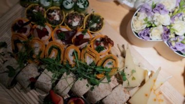 Farklı atıştırmalıklar ve aperatiflerle güzel servis edilmiş ziyafet masası. Düğün çifti için masa hazır.