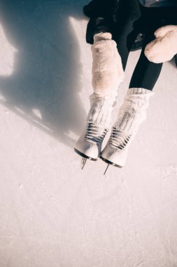 Kişi, parlak bir kış atmosferinde, kalın giysiler ve gümüş patenler içinde buzda kaymaktan zevk alır..