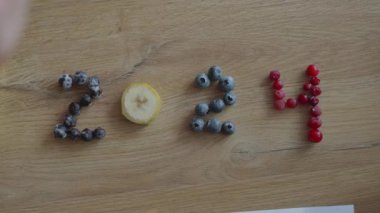 Meyvelerden oluşan canlı bir düzenleme 2025 yılını temsil eden sayıları oluşturuyor, yaratıcılık ve neşe sergiliyor..