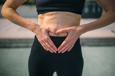 Bir kadın ellerini kalp şeklinde tutarken nefes alma teknikleri uyguluyor..