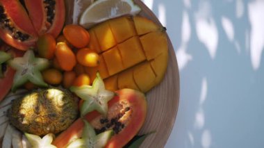 Kavanozda papaya, mango, kumkat ve yıldız meyveleri gibi canlı bir meyve çeşitliliği..