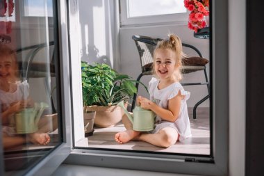 Sanatsal tırnakları olan bir el, canlı renkler ve dokular sergilenen karışık güllerin serpilmiş düzenine nazikçe dayanır..