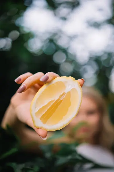 Limon meyvesi tutan pürüzsüz tenli güzel bir kadının açık hava portresi. Cilt bakımı
