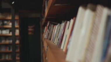 Kütüphane kitaplığı: renkli dikenler, sıcak ahşap, düzenli. Sakin düşünmek ve çalışmak için mükemmel.