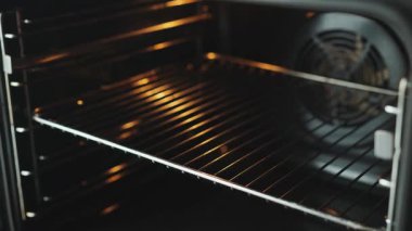 Ev yapımı pizzayı fırına koyan biri. Evde yemek pişirmek.