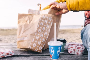 Tallinn, Estonya - 2 Nisan 2025: Güneş ve sıcaklığın tadını çıkarırken Hesburger 'den lezzetli hamburgerlerin ve içeceklerin tadını çıkarmak.