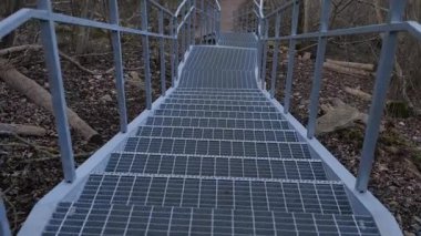 Sakin, ağaçlık bir ortamda yol gösteren metal geçitleri keşfedin. Akşam yürüyüşleri için mükemmel..