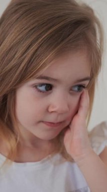 Düşünceli ve düşünceli bir genç kız sakin ve sessiz bir odada elini yüzüne koyuyor..