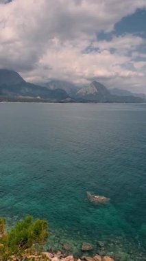 Rahatla ve bulutlu bir gökyüzünün altında dağların ve sakin bir denizin olduğu nefes kesici kıyı manzarasının tadını çıkar. Kemer, Antalya Türkiye