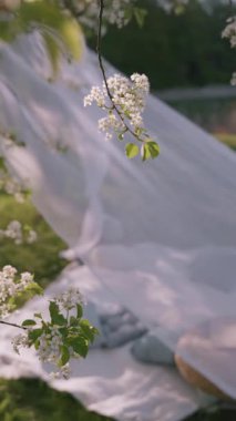 Narin çiçekler hafif esintide sallanıyor, bu huzurlu bahçe ortamında yumuşacık kumaş örtüsü tamamlıyor..