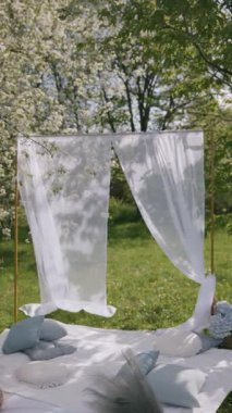 Akan beyaz perdelerle, yumuşak yastıklarla ve çiçek açan ağaçlarla güzel bir açık hava düzenlemesi huzur verici bir alan yaratır..