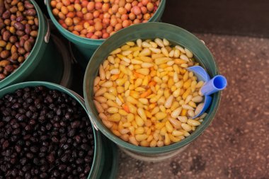 Çeşitli fındık ve tohumlarla dolu kovalar canlı bir pazarda, zengin renklerini ve dokularını sergiliyorlar..